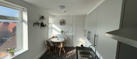 A compact kitchen with a dining area, a window, and a view of the outside.