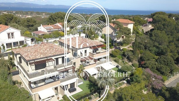 Une grande maison moderne à plusieurs niveaux, dotée d’un vaste espace extérieur et offrant une vue sur le paysage environnant.
