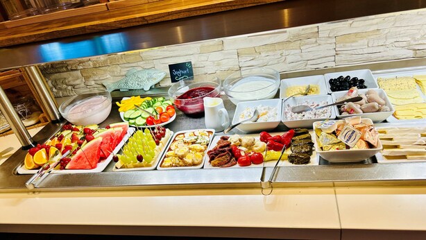A buffet with a variety of food items including fruits, cheeses, and olives. - Tauwerk Hotel (Wilhelmshaven)
