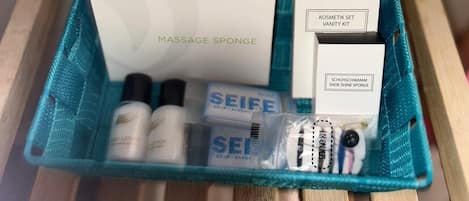 Un kit de cuidado personal que incluye una esponja de masaje, jabón, una esponja para limpiar zapatos y un kit de costura.