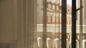 A room with a view through a window, featuring a chair and a table. - URBANAUTS BELETAGES Sonata (Trieste)
