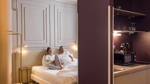 A modern bedroom with a bed, bedside tables, and a built-in TV. - URBANAUTS BELETAGES Sonata (Trieste)