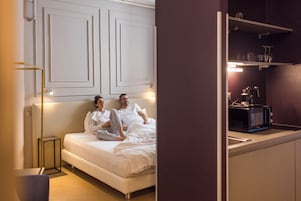 Una camera da letto moderna con un letto, comodini e TV a incasso.
