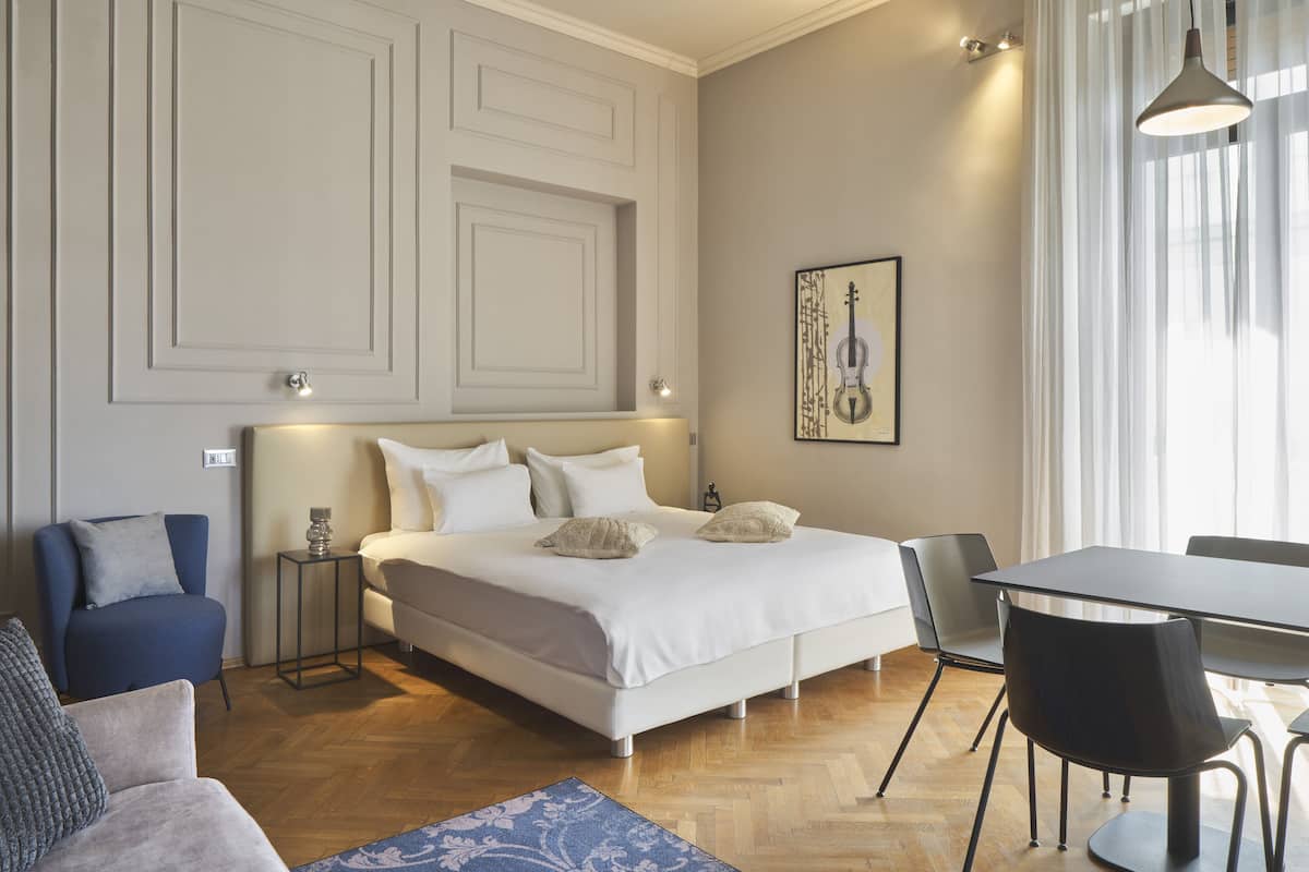 A bedroom with a bed, a desk, and a chair.