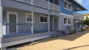 Un bâtiment à deux étages doté d’un balcon, situé sur une plage de sable.