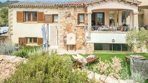 A two-story stone house with a balcony, a small garden, and outdoor seating. - Villa del Golfo (Olbia)