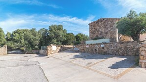 A stone building with a paved courtyard, surrounded by trees and a stone wall. - Villa del Golfo (Olbia)