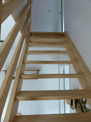 A wooden staircase with a simple design, leading to a door.