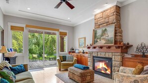 Una sala de estar con chimenea, un sofá, una mesa de centro y un comedor con una mesa y sillas.
