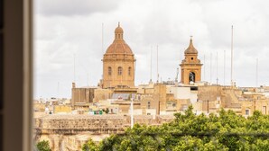 A historic building with a large dome and a bell tower, surrounded by other structures and greenery. - Yolanda Boutique Hotel  (Birgu)