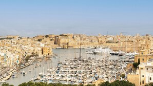 A marina filled with numerous boats, surrounded by historic buildings and a clear sky. - Yolanda Boutique Hotel  (Birgu)