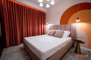 Une chambre à coucher moderne avec un grand lit, une tête de lit et une table de chevet.