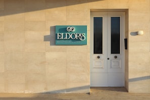 L’entrée d’un immeuble, avec une enseigne indiquant : « Eldors Boutique Living ».