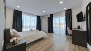 Una habitación de hotel moderna con una cama grande, un escritorio, una silla y un televisor.