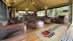 A tented accommodation with a dining area, kitchen, and seating area with sofas and a rug. - Haus der Pferde, Luxuszelte, Wildtier-reservat, Privater Koch, Hausmädchen,natur (Naivasha)