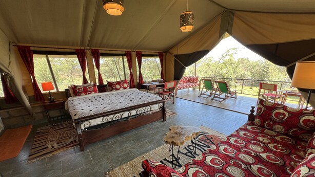 A spacious tented room with a large bed, a sofa, and a balcony with chairs. - Haus der Pferde, Luxuszelte, Wildtier-reservat, Privater Koch, Hausmädchen,natur (Naivasha)