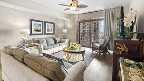 Ein großzügiges Wohnzimmer mit einer Couch, Couchtisch und einem Balkon mit Blick.