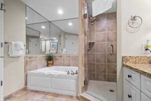 A modern bathroom with a bathtub, shower, and vanity.