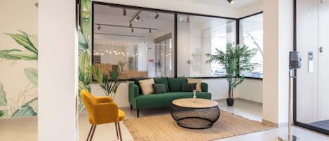 A modern interior with a green sofa, yellow chair, and a round coffee table.