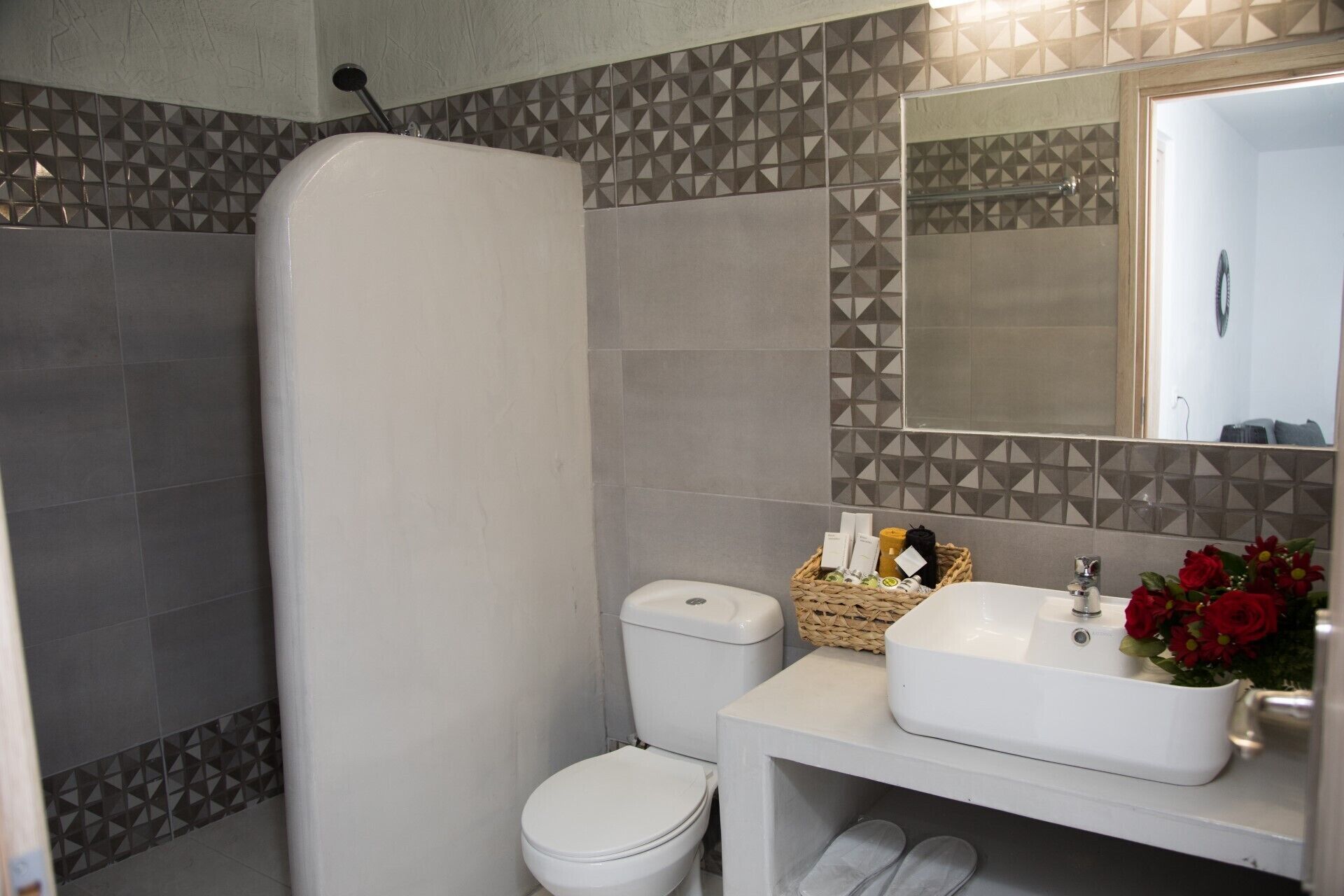 Een badkamer met douche, toilet en wastafel.