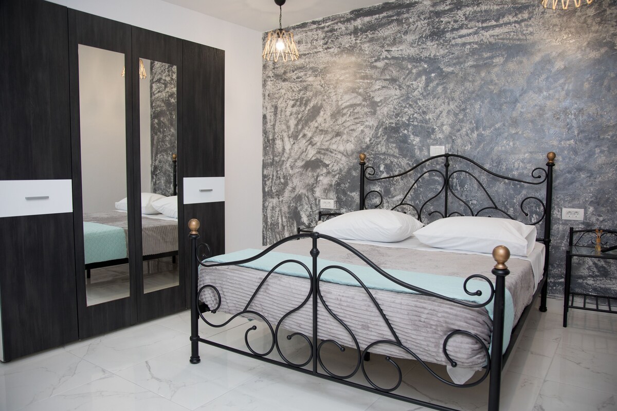 Quarto com cama, guarda-roupa e parede texturizada.