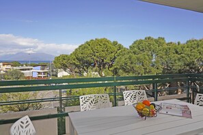 Ein Balkon mit Tisch, Stühlen und einer Obstschale.