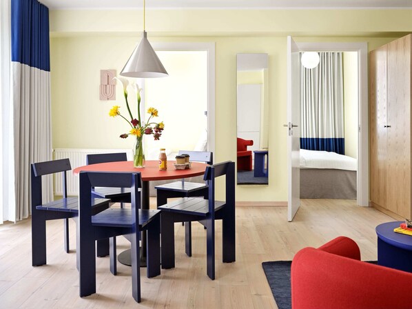 A modern hotel room with a dining area, a bed, and a bathroom visible through an open door. - 2 Bedroom Apartment for 6 (København)