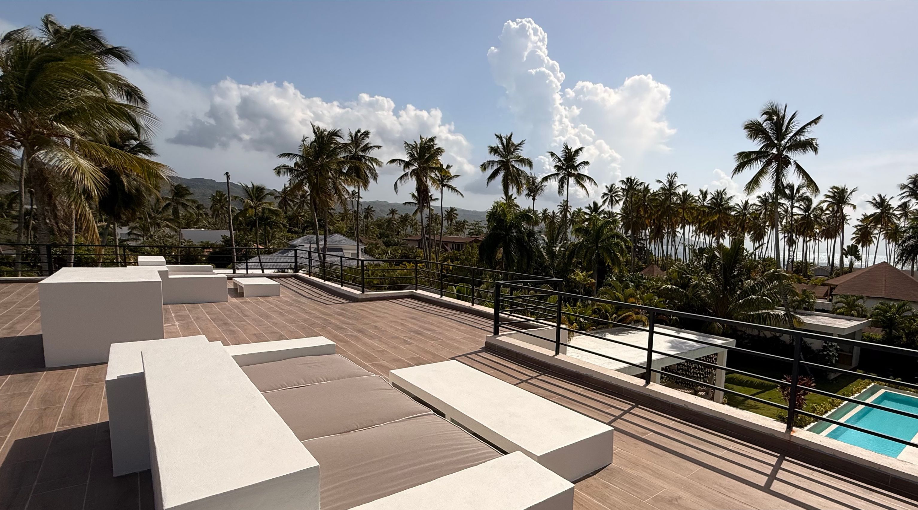 A rooftop terrace with modern seating and a pool view.