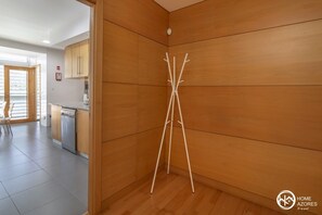 A modern kitchen with wooden cabinets and a white countertop. - Home Azores - Pico do Salomão Poolside Retreat (Ponta Delgada)
