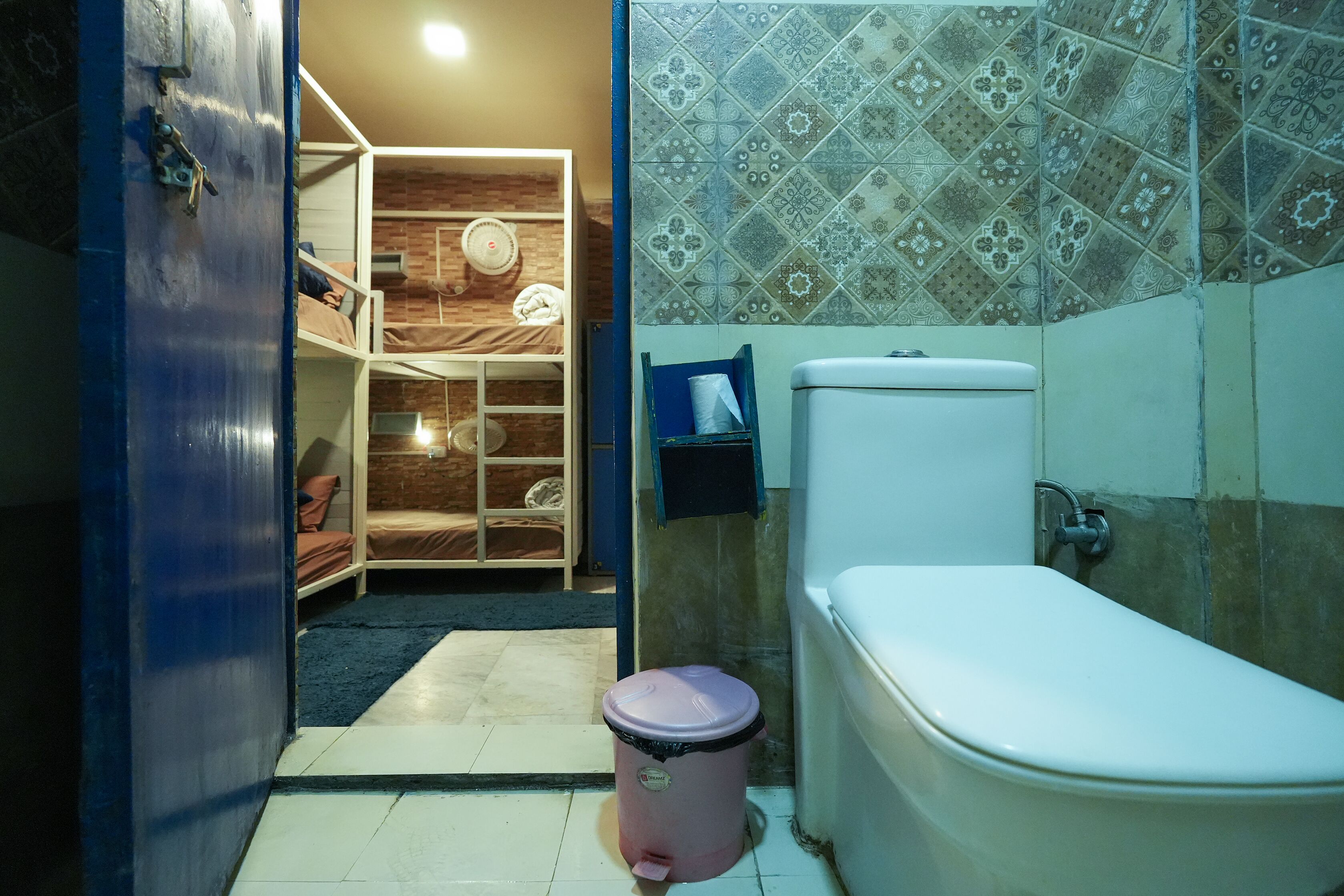 Un baño pequeño con inodoro, cubo de basura y zona de ducha.