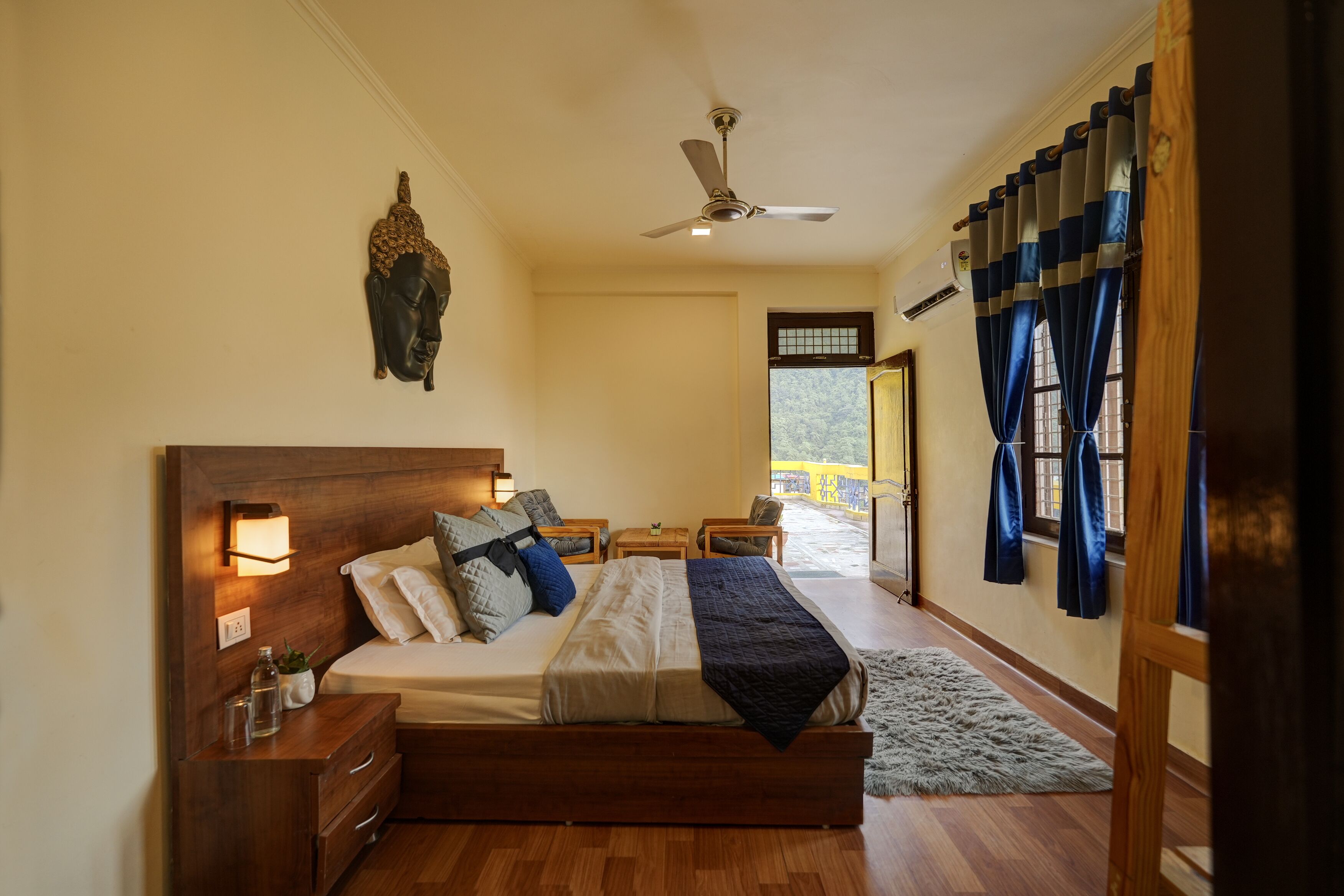 A bedroom with a wooden bed, bedside tables, a ceiling fan, and a view of the outside.