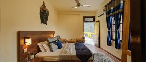 A bedroom with a wooden bed, bedside tables, a ceiling fan, and a view of the outside.