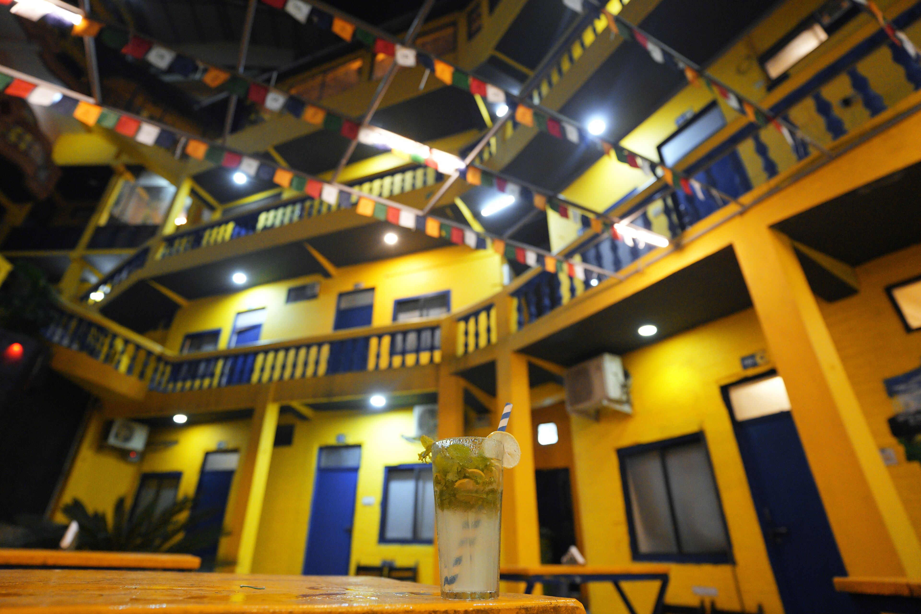 A multi-level building with balconies and a table with a drink.