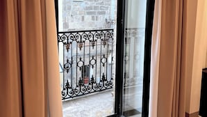 A sliding glass door leading to a balcony with a stone building in the background. - RESIDENZA ORTENSIA (Petacciato)