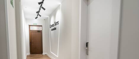Un pasillo con piso de madera, una puerta con la etiqueta 'Salida' y un letrero que dice 'Centro Suite Aguascalientes'.