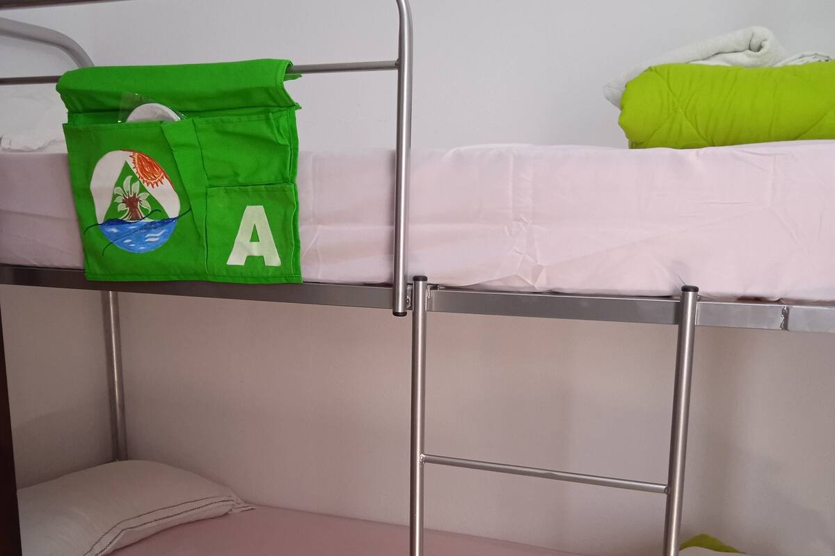 Bed in mixed shared room. | Ropa de cama de alta calidad y edredones de plumas