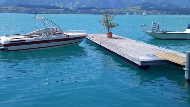 A boat docked at a pier with a mountain backdrop. - North West London 2-bed Apt, Sleeps 3 (London)