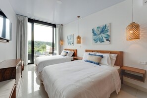 A modern hotel room with two beds, a large window, and artwork on the walls.