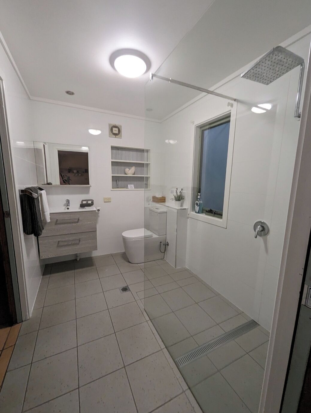 Un baño moderno con inodoro, lavabo y ducha.