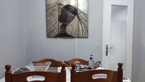 A room with a bed, wooden chairs, a table with toiletries, and a wall art piece. - Smart cozy apartment in Athens !!  (Athina)