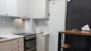A compact kitchen with white cabinets, a stainless steel oven, and a small countertop. - Smart cozy apartment in Athens !!  (Athina)