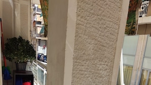 A balcony with a potted plant, a broom, and a red bucket. - Smart cozy apartment in Athens !!  (Athina)