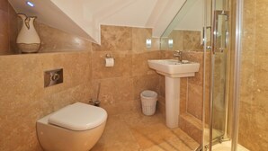 Un baño con inodoro, lavamanos y ducha.