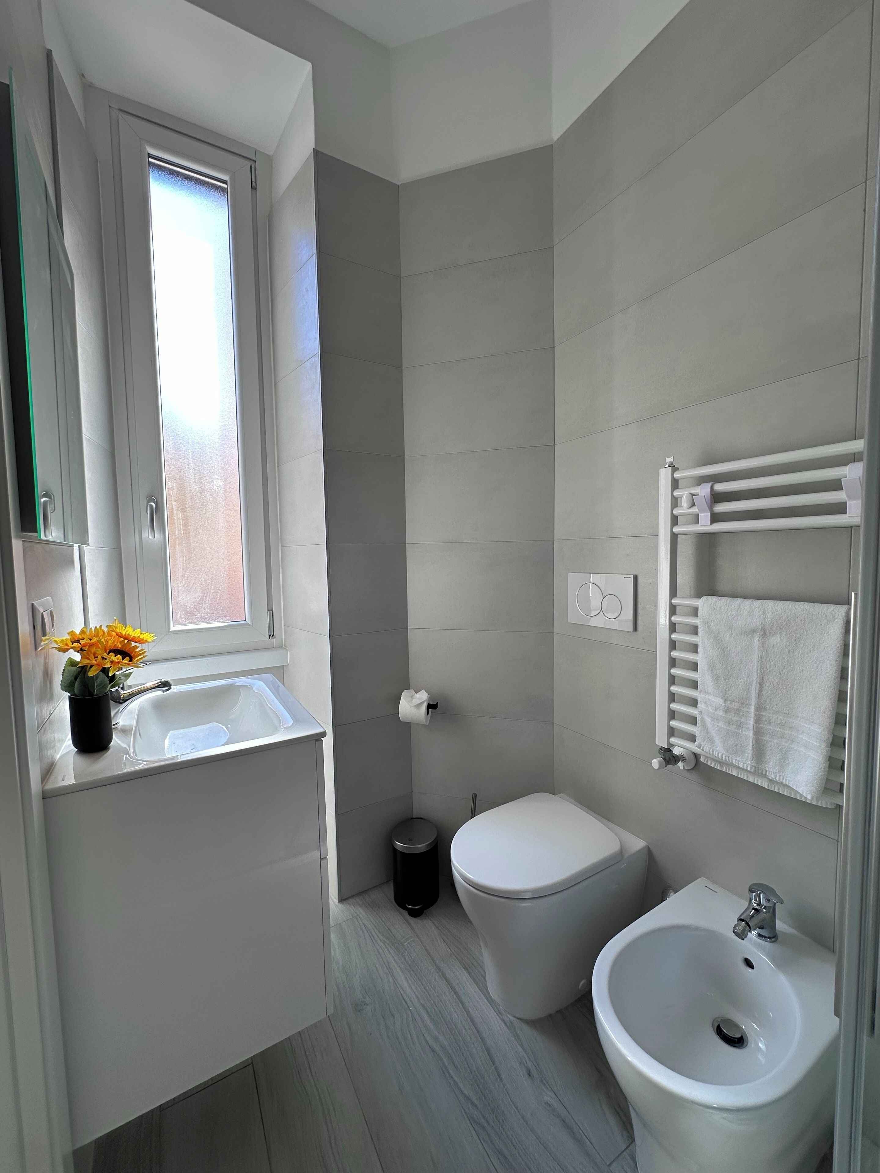 A modern bathroom with a sink, toilet, and bidet.