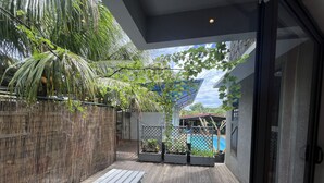 A wooden deck with a bamboo fence and potted plants.