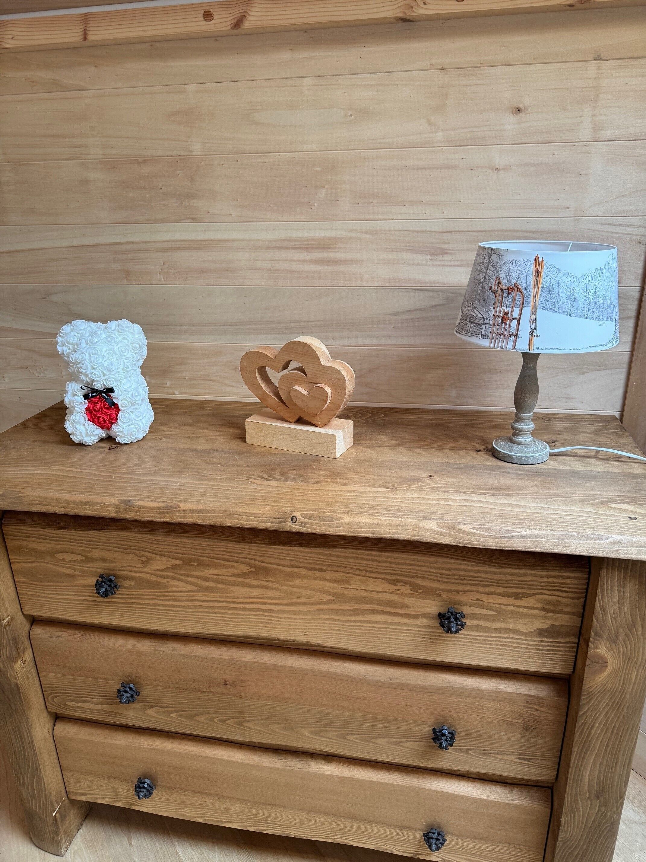 A wooden dresser with drawers, a lamp, and decorative items.