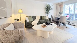 Ein modernes Wohnzimmer mit Sofa, Couchtisch und Essbereich.