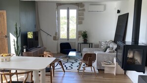 Un vaste espace de vie comprenant une table à manger, des chaises, un canapé et une cheminée.