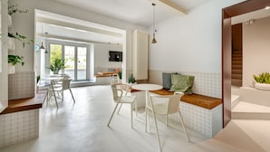 A modern kitchen with white cabinetry, a round dining table, and white chairs. - Villa Fedora Luxury Suites (Lucca)