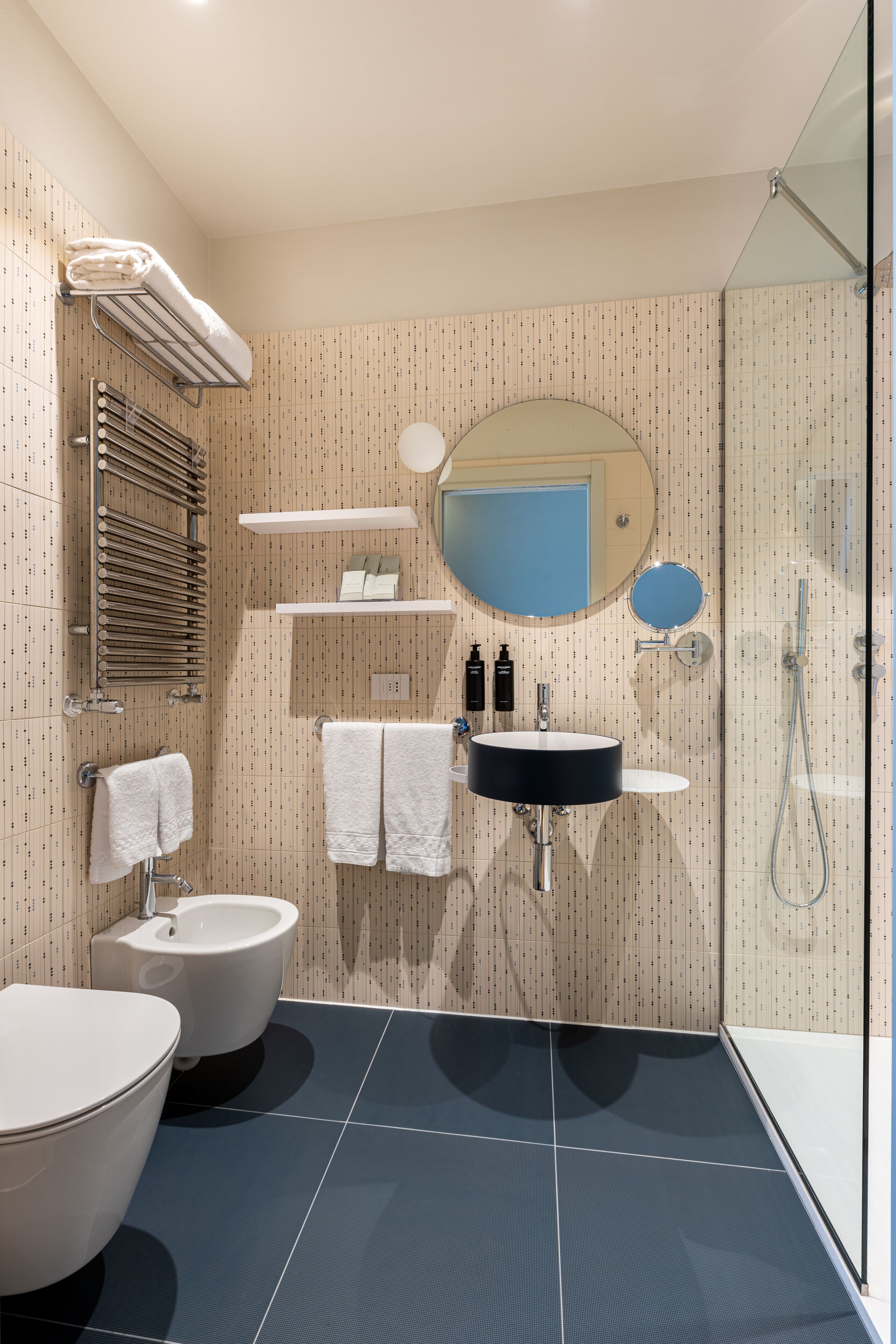 A modern bathroom with a toilet, bidet, and a glass-enclosed shower.